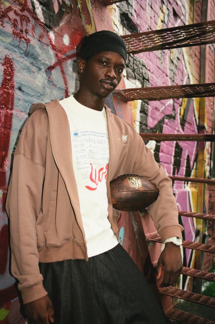 Deji holding a basketball in a graffiti stairwell
