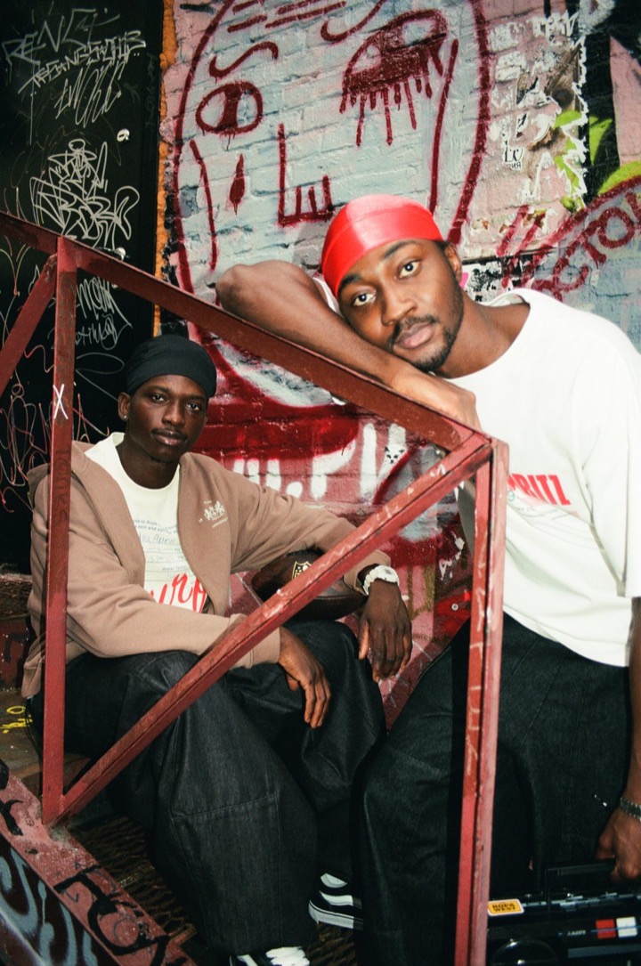 Deji with another model on a red stair rail